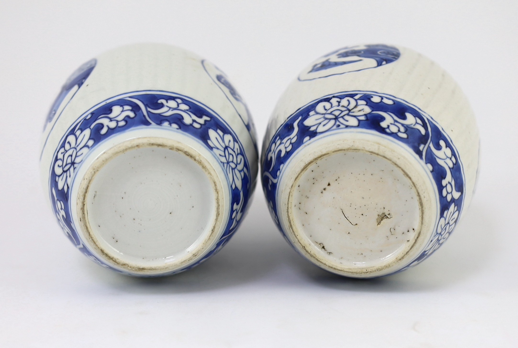 A pair of Chinese blue and white ribbed ovoid jars, Kangxi period, 13.4cm high, excluding wood stand and cover, one chipped with hairline crack